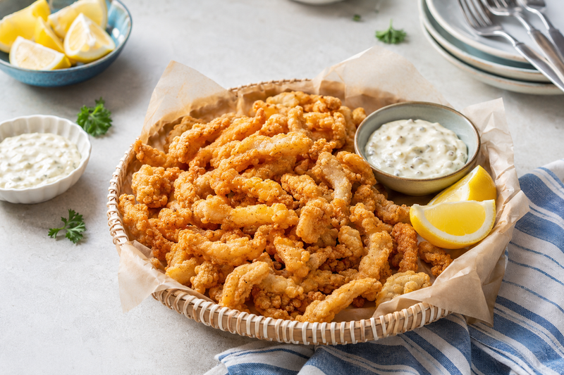 Crispy golden fried clam strips with lemon and tartar sauce