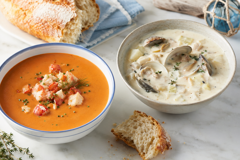 Creamy seafood bisque and New England clam chowder served with bread