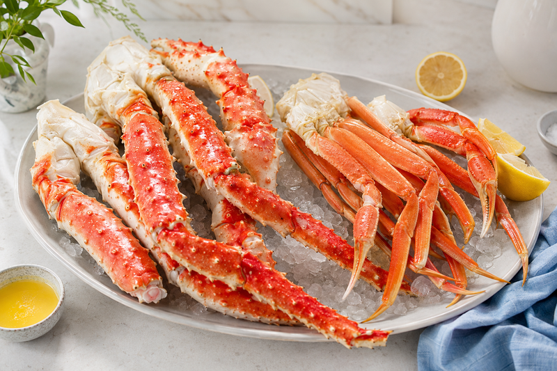 Large king crab legs and slender snow crab clusters arranged side by side