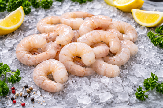 Raw shrimp on a bed of ice with lemon wedges and parsley