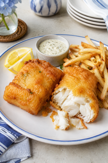 Beer-battered cod portions with flaky white fish, fries, lemon and tartar sauce